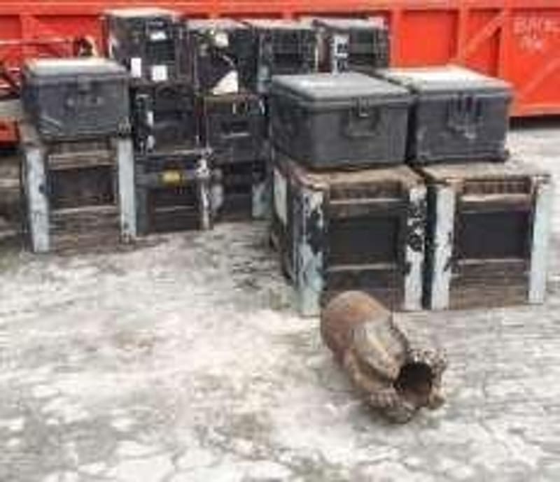 Caixas de transporte de ferramentas e uma broca preparadas num parque de equipamentos